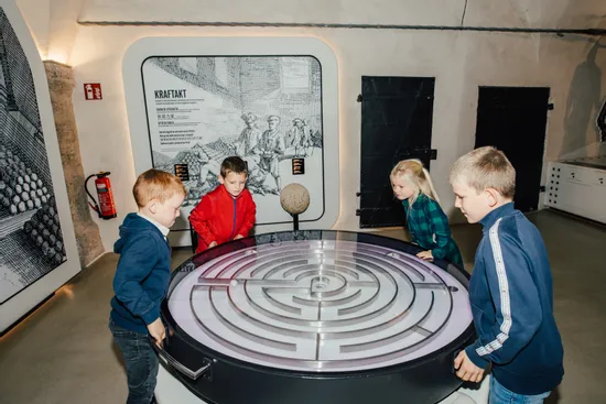 Kinder spielen mit interaktivem Labyrinthtisch in einer Wissenschaftsausstellung